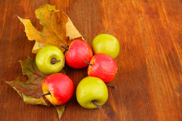 Small apples on wooden background