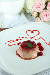 Panna Cotta with raspberry sauce, on wooden background