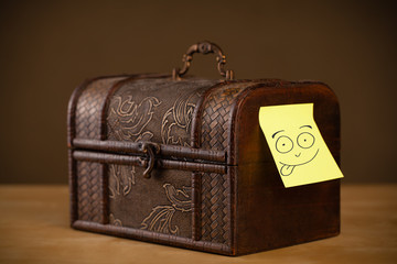 Post-it note with smiley face sticked on a jewelry box