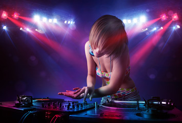 Teenager Dj mixing records in front of a crowd on stage