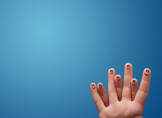 Happy smiley face fingers looking at empty blue background copy
