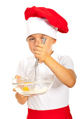 Boy chef mixing egg with flour
