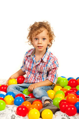 Fototapeta na wymiar Toddler boy sitting on colorful balls