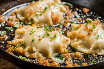 Closeup of .dumplings fried with onion and parsley