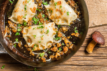 Closeup of dumplings with mushrooms, onion and parsley