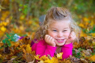 girl is lying in autumn foliage