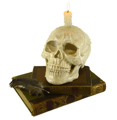 Human skull with candle and books