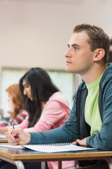 Young students writing notes in classroom