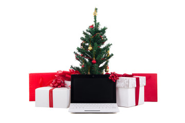 decorated christmas tree, gift boxes and laptop on white backgro