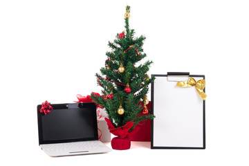 decorated christmas tree, computer and gift list on white backgr