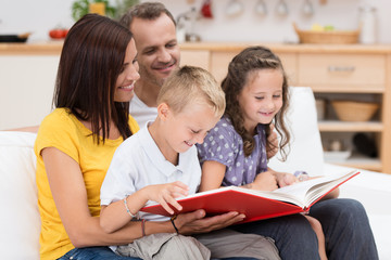 familie liest gemeinsam in einem buch