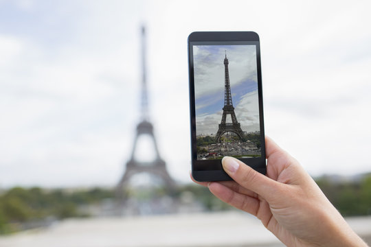 Woman in Paris taking pictures in front of Eiffel Tower, Cell ph