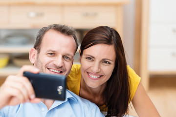 lachendes paar schaut auf smartphone