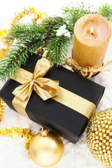 Fototapeta na wymiar Golden Christmas composition with gift box, candle and branch of