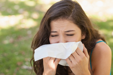 Sick young woman using a handkerchief