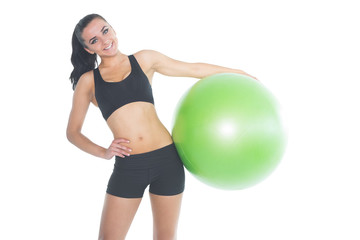 Fototapeta premium Attractive fit woman posing holding a green exercise ball