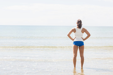 Fototapeta na wymiar Slender fit woman standing on the beach