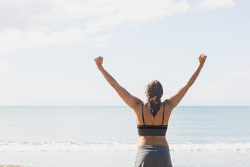 Fototapeta na wymiar Content brunette woman standing on the beach