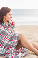 Fototapeta premium Woman covered with blanket at beach