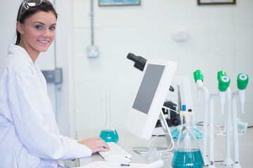 Young female researcher using computer in lab