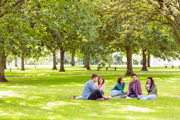 College students sitting on grass in park