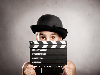 little girl holding a movie clapper board