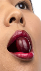 Closeup of woman mouth eating red grape