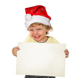 Kleiner Junge mit Weihnachtsmütze hält eine weiße Tafel