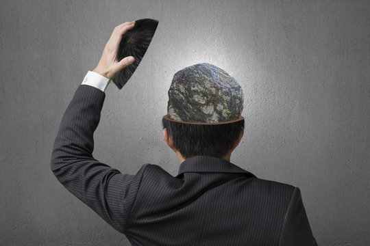 Hard stone covered with lines inside businessman head in gray co