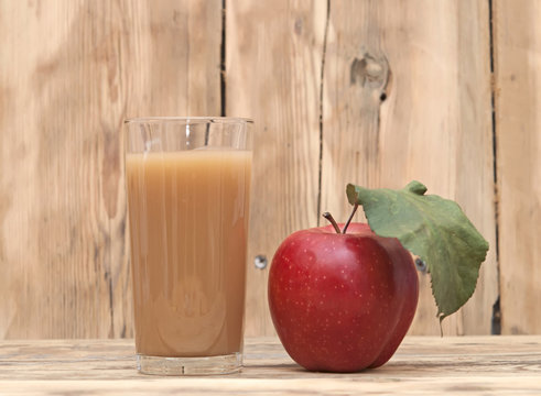 apple with apple juice on a wooden background