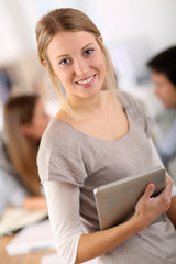 Beautiful young woman at work using tablet