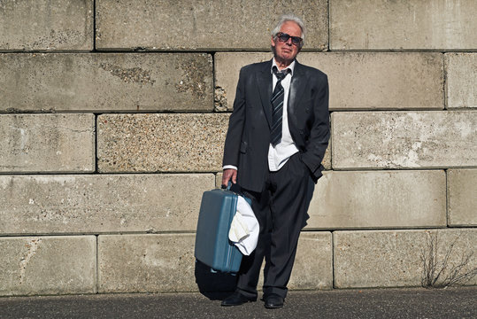Lonely wandering depressed senior business man with sunglasses w