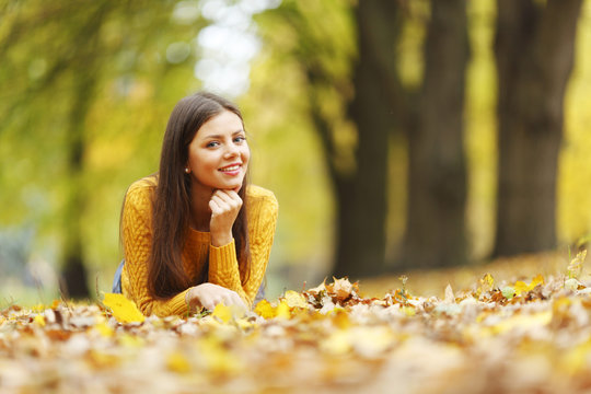 Girl laying on autumn leafs