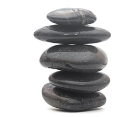 Black massage stones stacked, isolated on white