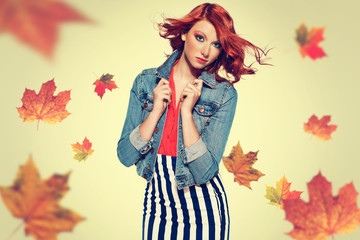 autumn picture of young beautiful red haired girl with leaves