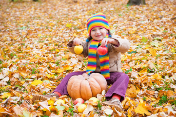 girl in autumn park with pumpkin and apples