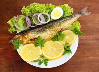 Smoked fish on plate on wooden table