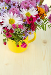 Wildflowers in mug on wooden table