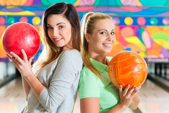 Junge Frauen spielen Bowling auf Bowlingbahn