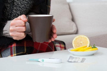 Hot lemon tea, thermometer and medication
