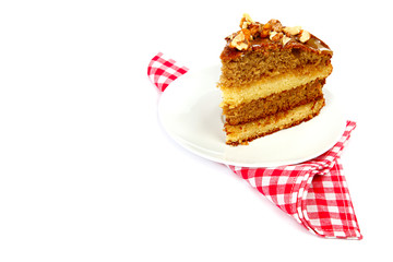 Piece of cake in a saucer with red napkin isolated on white back