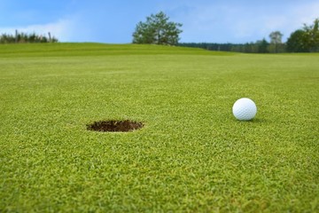 Golf, ball lying on the green next to hole