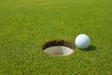 Golf, ball lying on the green next to hole