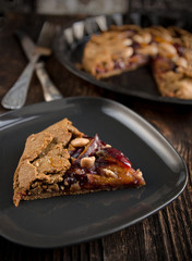 Whole-grain cereal biscuit with plums on the wood background