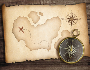 Adventure concept. Old compass on table with treasure map.
