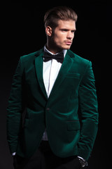 side view of a young elegant man in green velvet suit