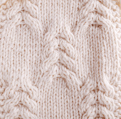 Close-up of knitted cloth with raised plaits.