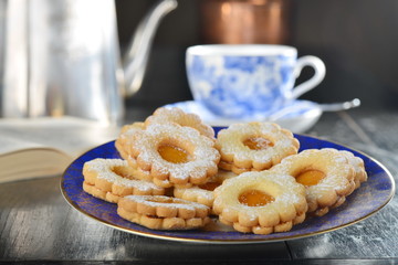 Delicious jam cookies with cup of English tea and book - obrazy, fototapety, plakaty