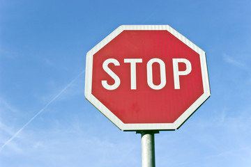 Stop road traffic sign over blue sky