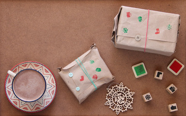 Christmas wrapped presents with cup of hot chocolate and stamps